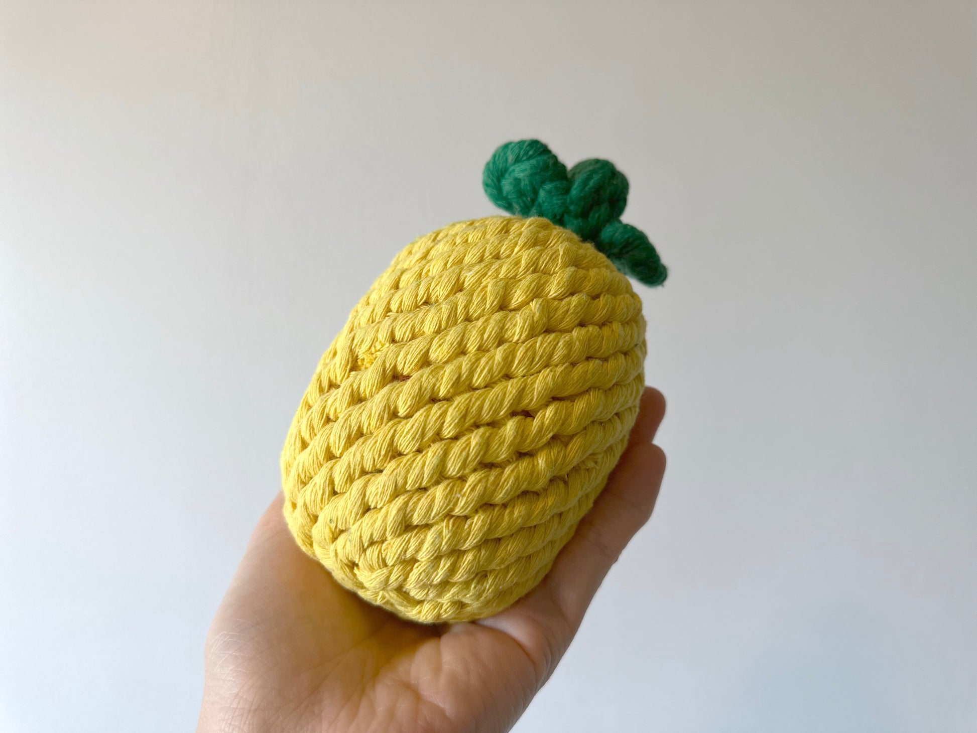 A pineapple-shaped pet toy made from durable cotton rope, perfect for chewing and interactive play, promoting dental health and keeping pets entertained.