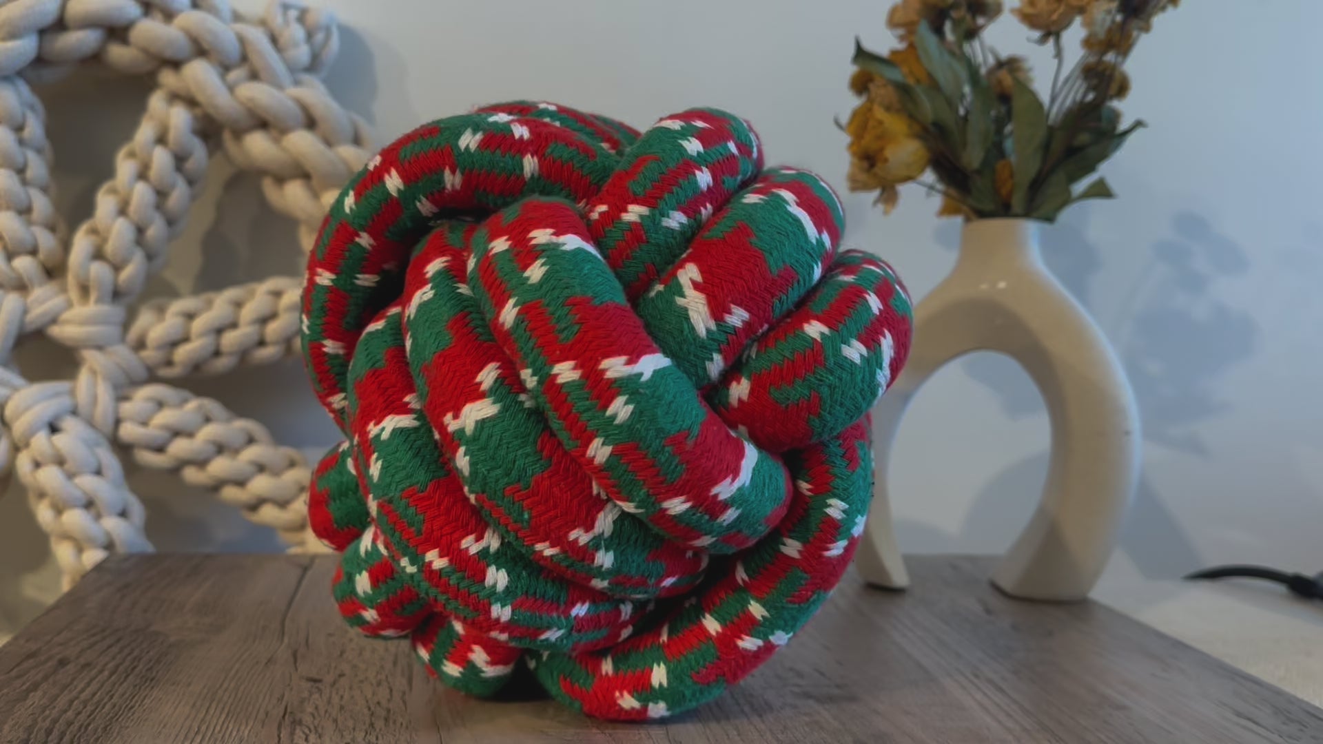 A festive Christmas-themed pet toy featuring a large ball woven with cotton rope. The image shows a front view of the colorful, durable toy, perfect for pets to play and chew on during the holiday season. Ideal for keeping pets entertained and engaged.